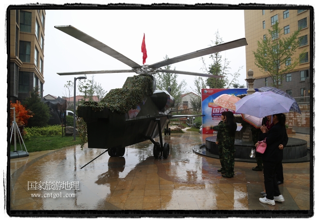 小區(qū)突然出現(xiàn)“飛機坦克”，其中殲15艦載戰(zhàn)斗機一架、99式主戰(zhàn)坦克一輛、武直-10武裝直升機一架，吸引了眾多市民雨中圍觀、合影。